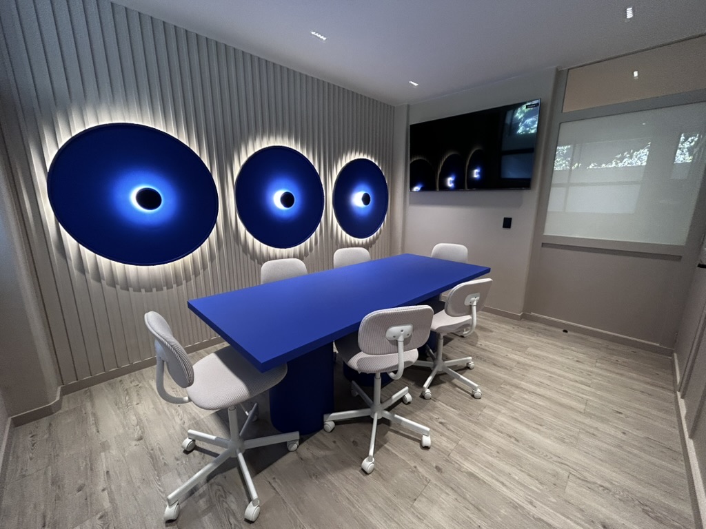 Sala de juntas de Estudio Popnest con mesa azul y luces circulares